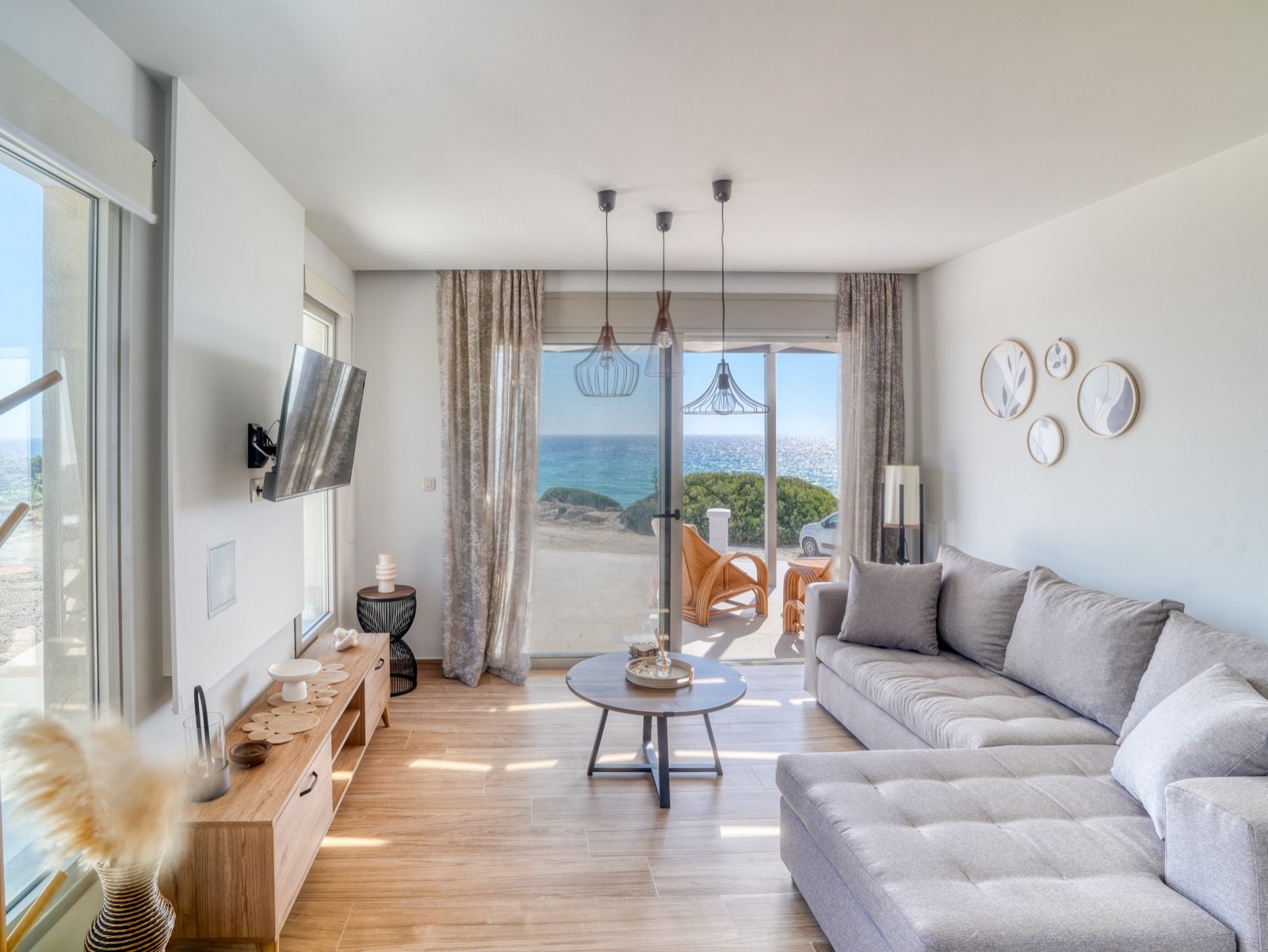 Living room with grey corner sofa and sea-view terrace